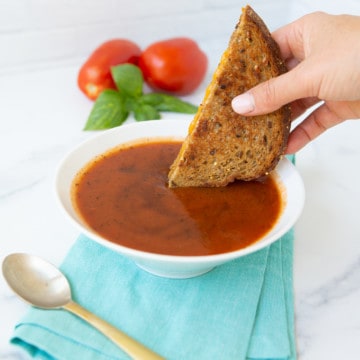 Dipping grilled cheese into a bowl of tomato soup