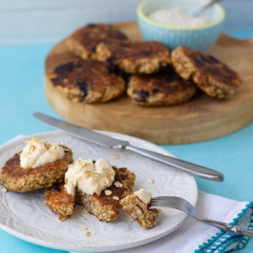 oatmeal griddle cakes on a plate with whipped honey ricotta on top