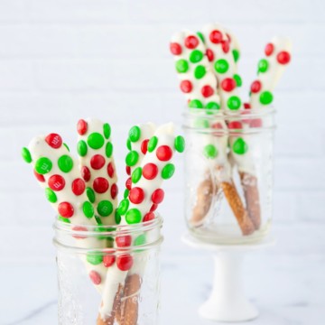 white chocolate dipped pretzel rods with m&ms in mason jar