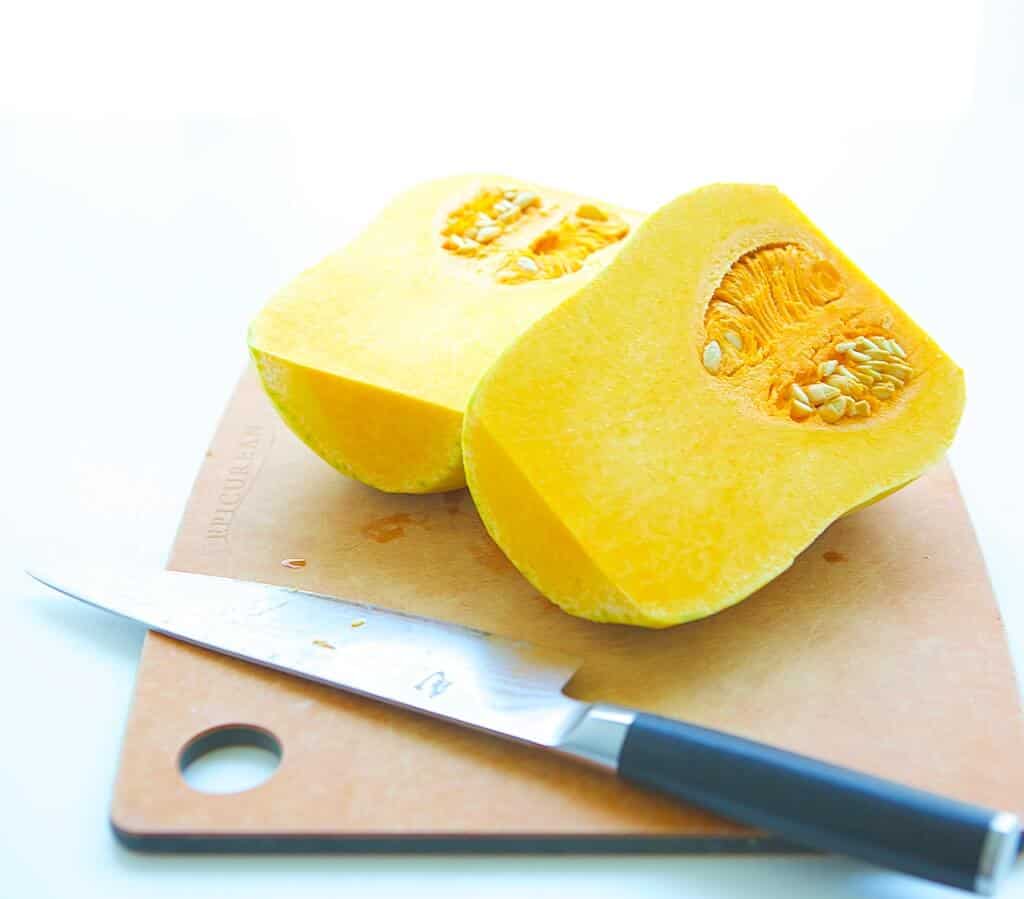 cutting board, knife, butternut squash sliced in half