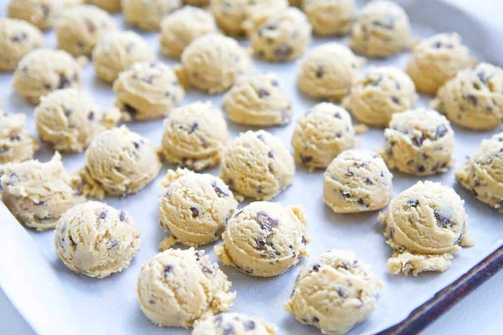 rounded scoops of the best chewy chocolate chip cookie dough on a baking sheet ready to go into the oven 