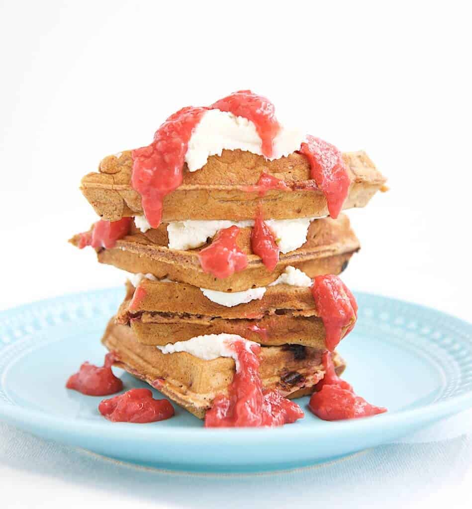 A delicious tower of whole grain strawberry waffles with strawberry sauce.