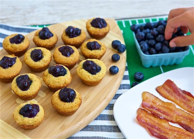 Boozy Blueberry Bacon Bites and someone taking some blueberries from a bowl