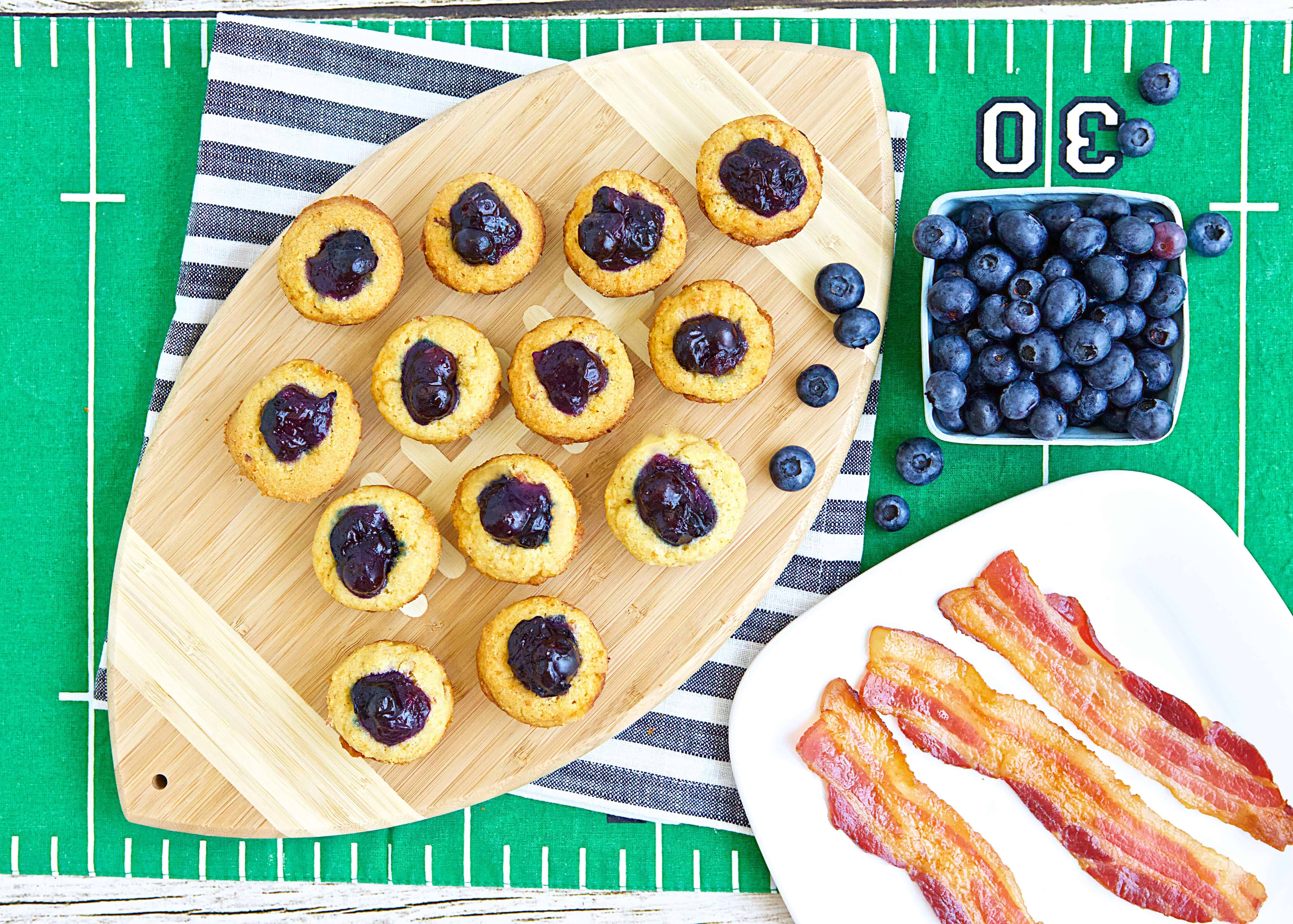 Boozy Blueberry Bacon Bites next to a bowl of blueberries and a plate of bacon