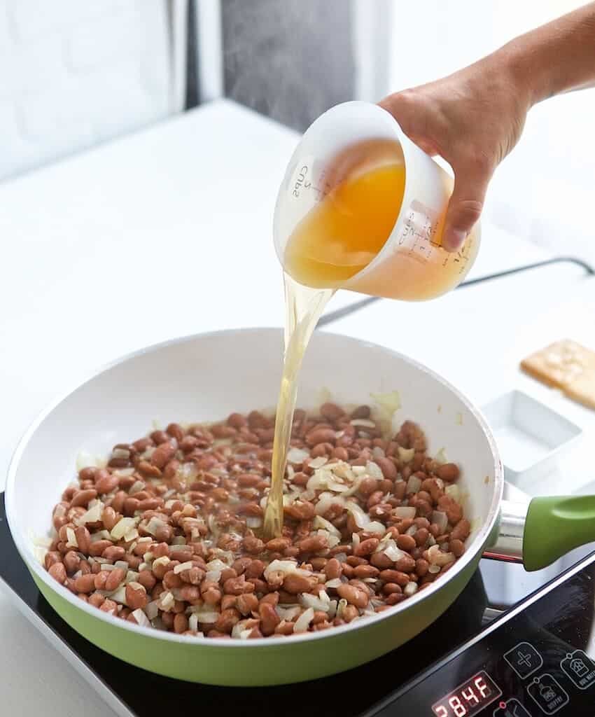 Pouring the stock into the pan.