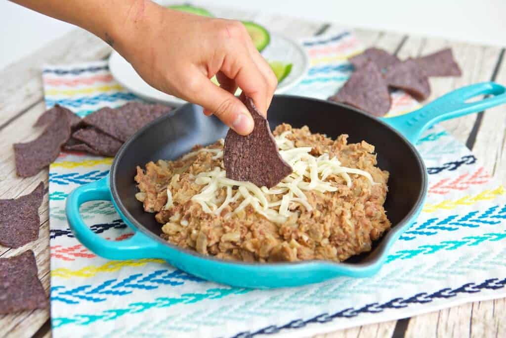 Dipping a chip into the vegan refried beans.