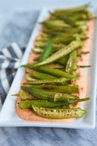 Elevate your appetizer or side dish scene with this sophisticated, yet simple to prepare, Roasted Okra with Smoky Red Pepper Ricotta recipe.