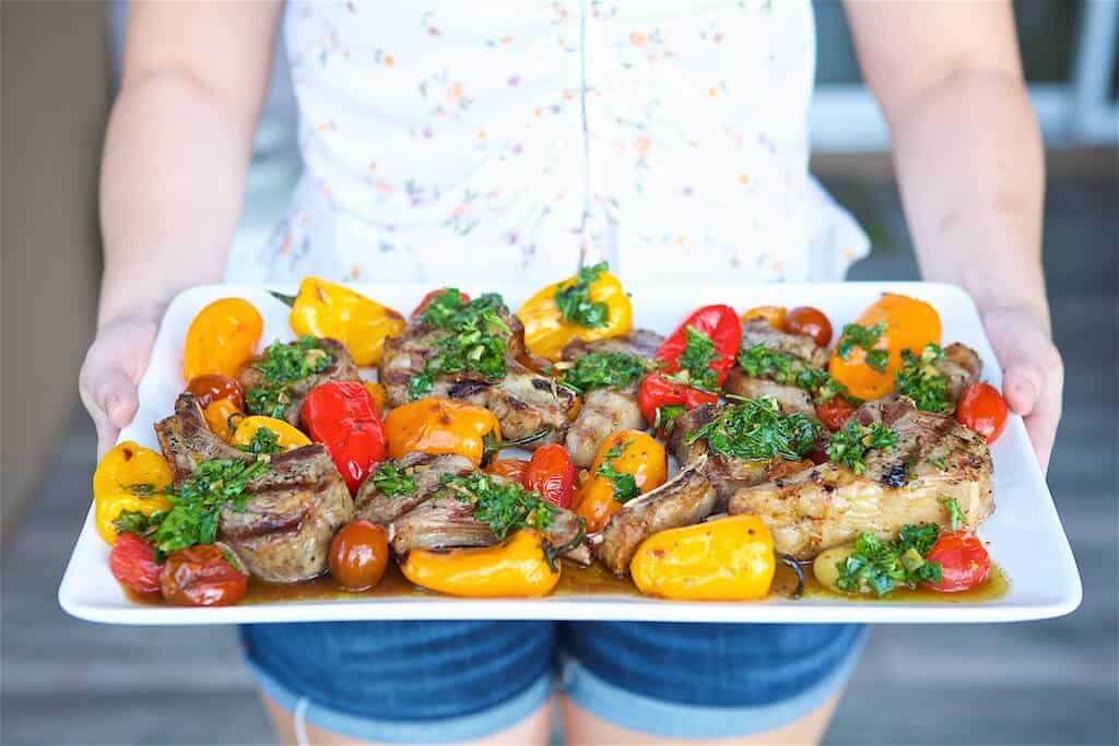 Jenna holding a platter of Grilled Lamb Chops and Vegetables with Chimichurri Sauce