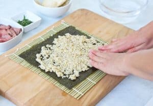 Spreading sushi rice on nori