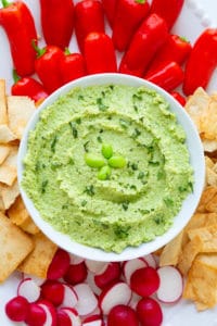 Edamame hummus with peppers, pita chips, and radishes