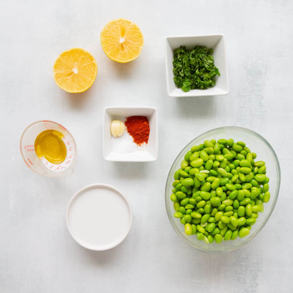 Ingredients laid out on table for green healthy hummus recipe.