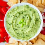 Edamame hummus with peppers, pita chips, and radishes