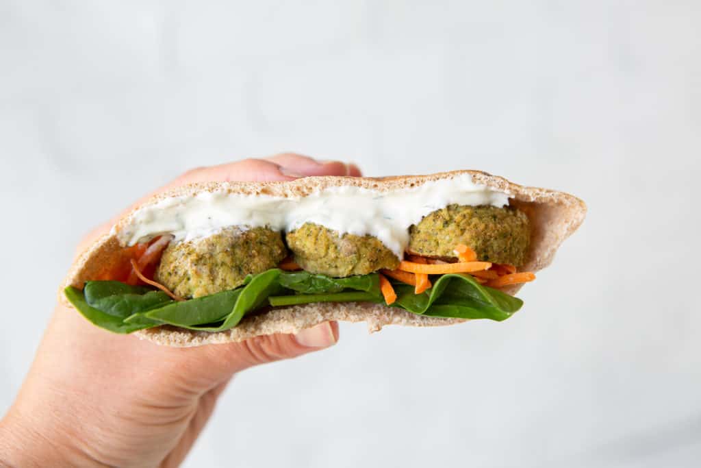 healthy hacks for plant based eating - Whole wheat pita with meatballs, sauce, spinach, and carrots