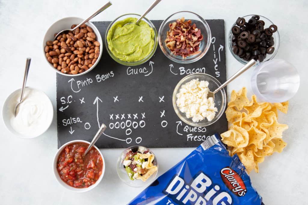 tortilla chips and bowls of dip on a serving tray