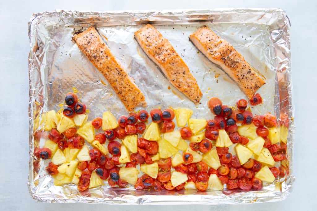 Cooked salmon, tomatoes and pineapple in Sheet pan salmon dinner