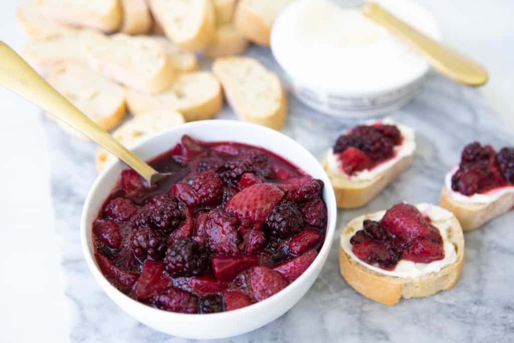 Cabernet berry compote in bowl shown on top of crostini with mascarpone cheese