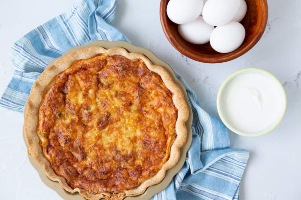 Easy Quiche Recipe - baked quiche pictured with eggs and yogurt