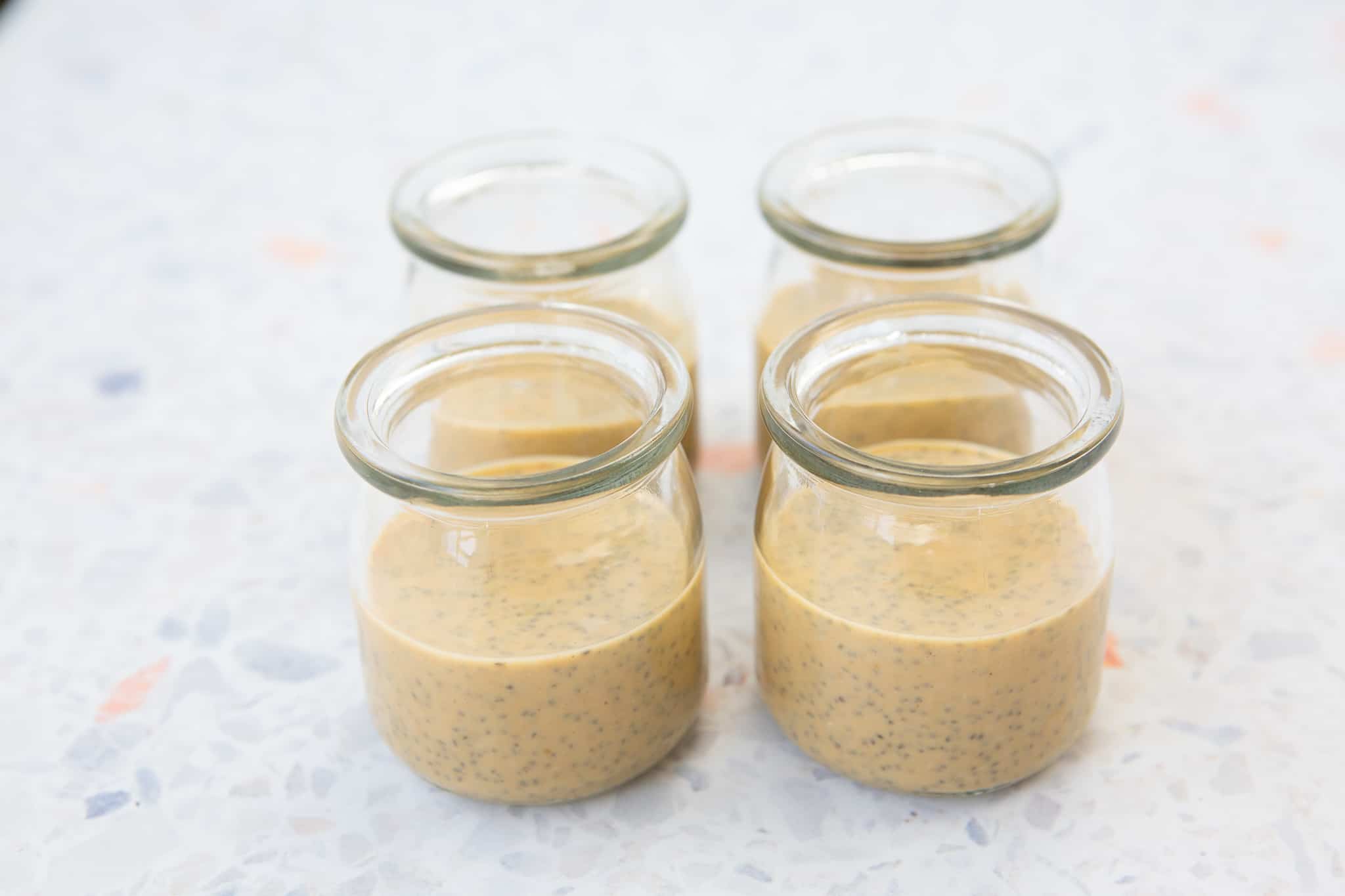 Prepared peanut butter chia layer poured evenly into 4 small jars