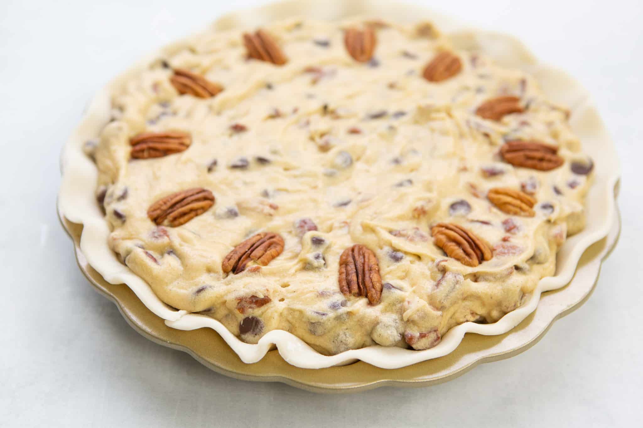 chocolate Chip pecan pie batter poured into prepared pie pan