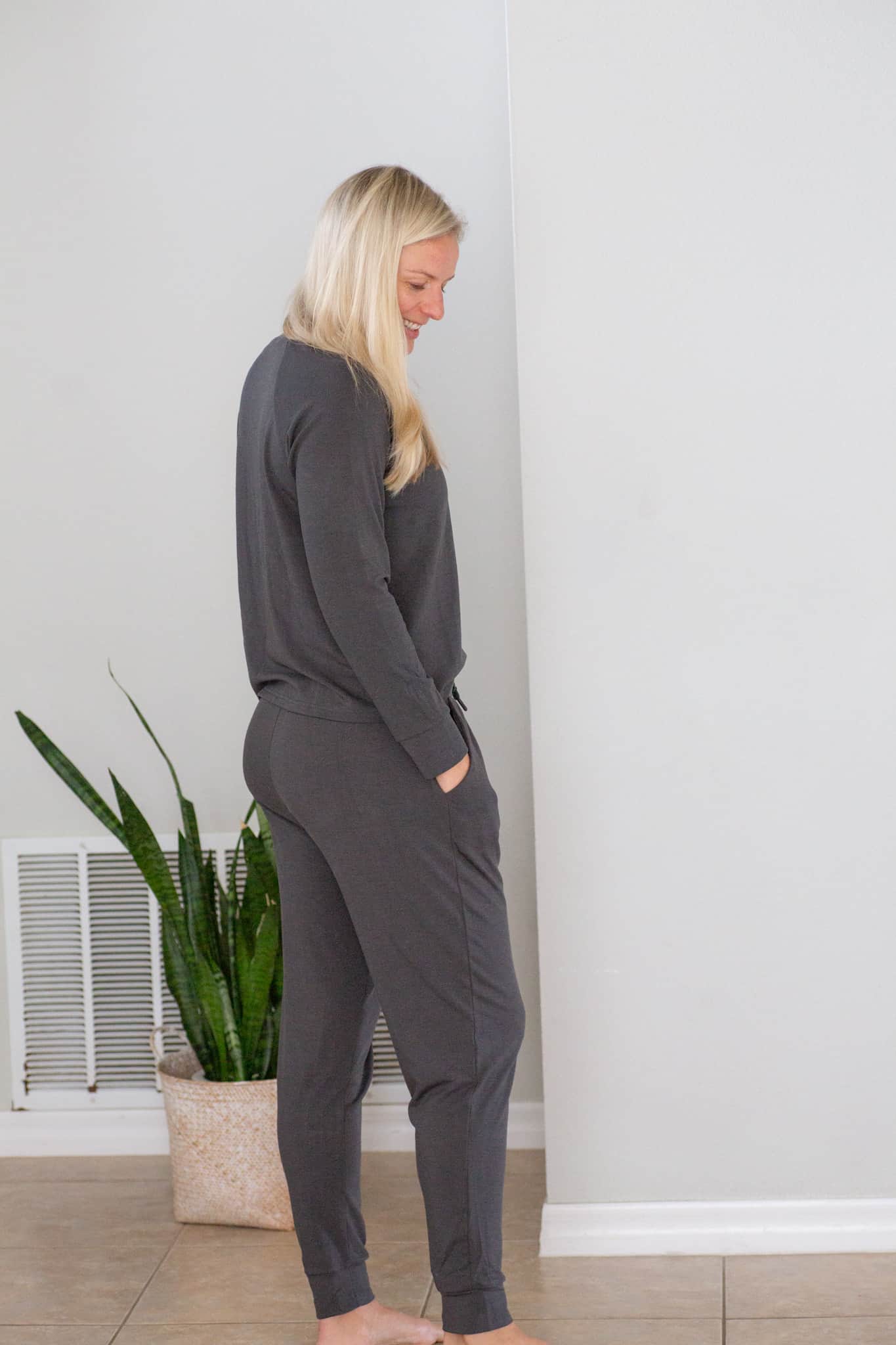 Jenna wearing Cozy Earth loungewear in grey. Rear view