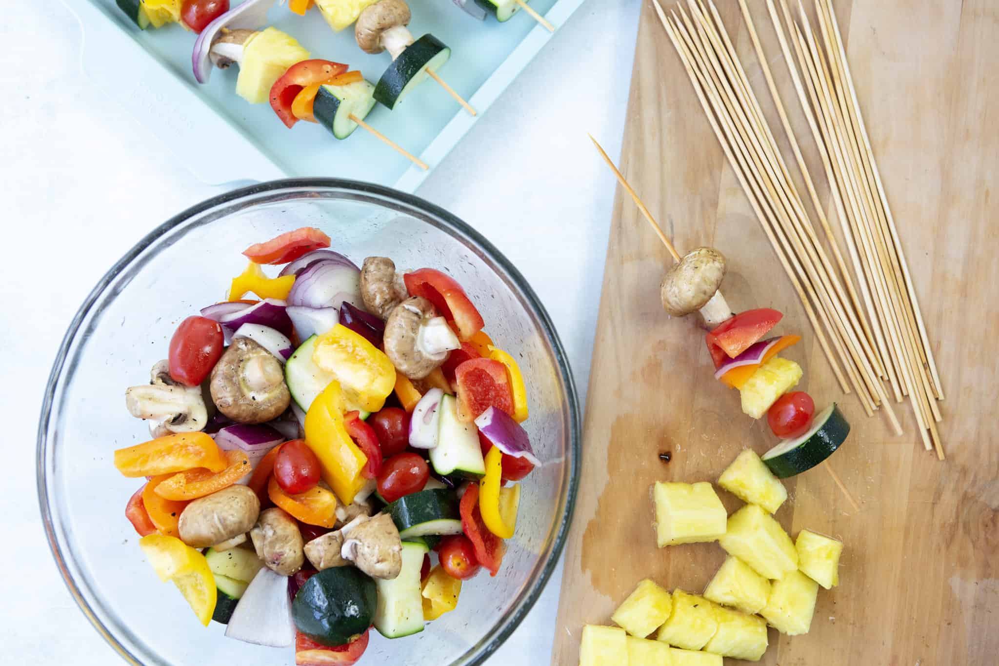 Fruit and veggies chopped up and placed in a bowl, ready to be placed on wooden skewers.