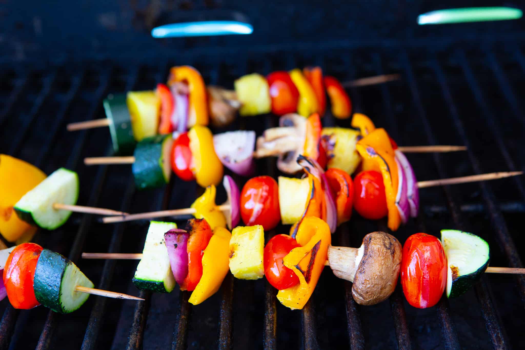 kabobs on the grill with chopped onion, zucchini, tomatoes, peppers, mushrooms, and pineapple