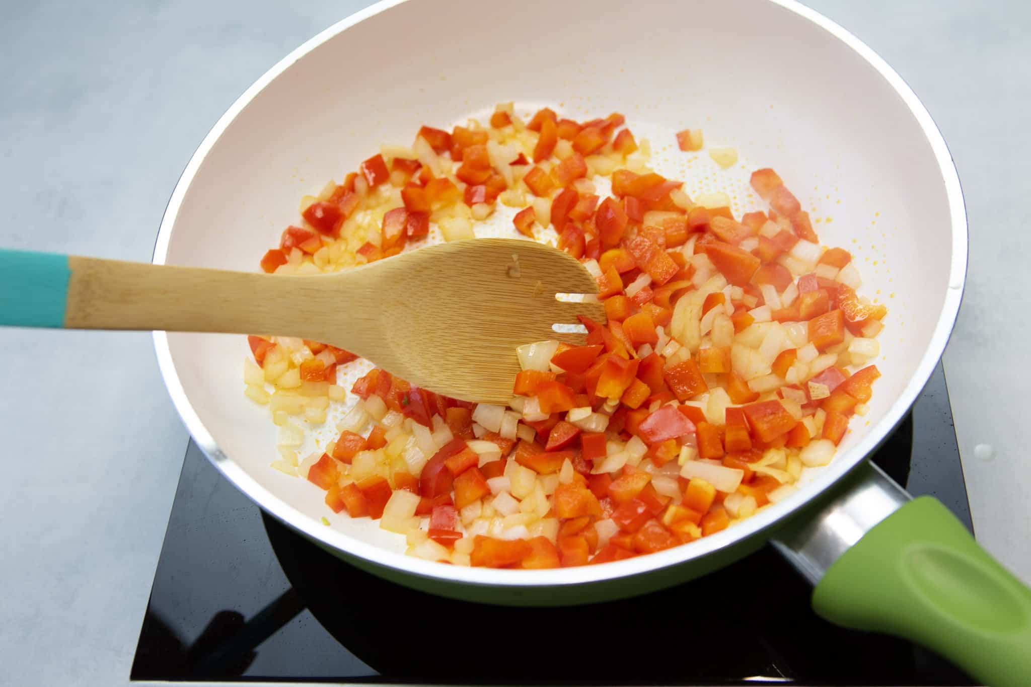 Onions and peppers sauteed in a pan