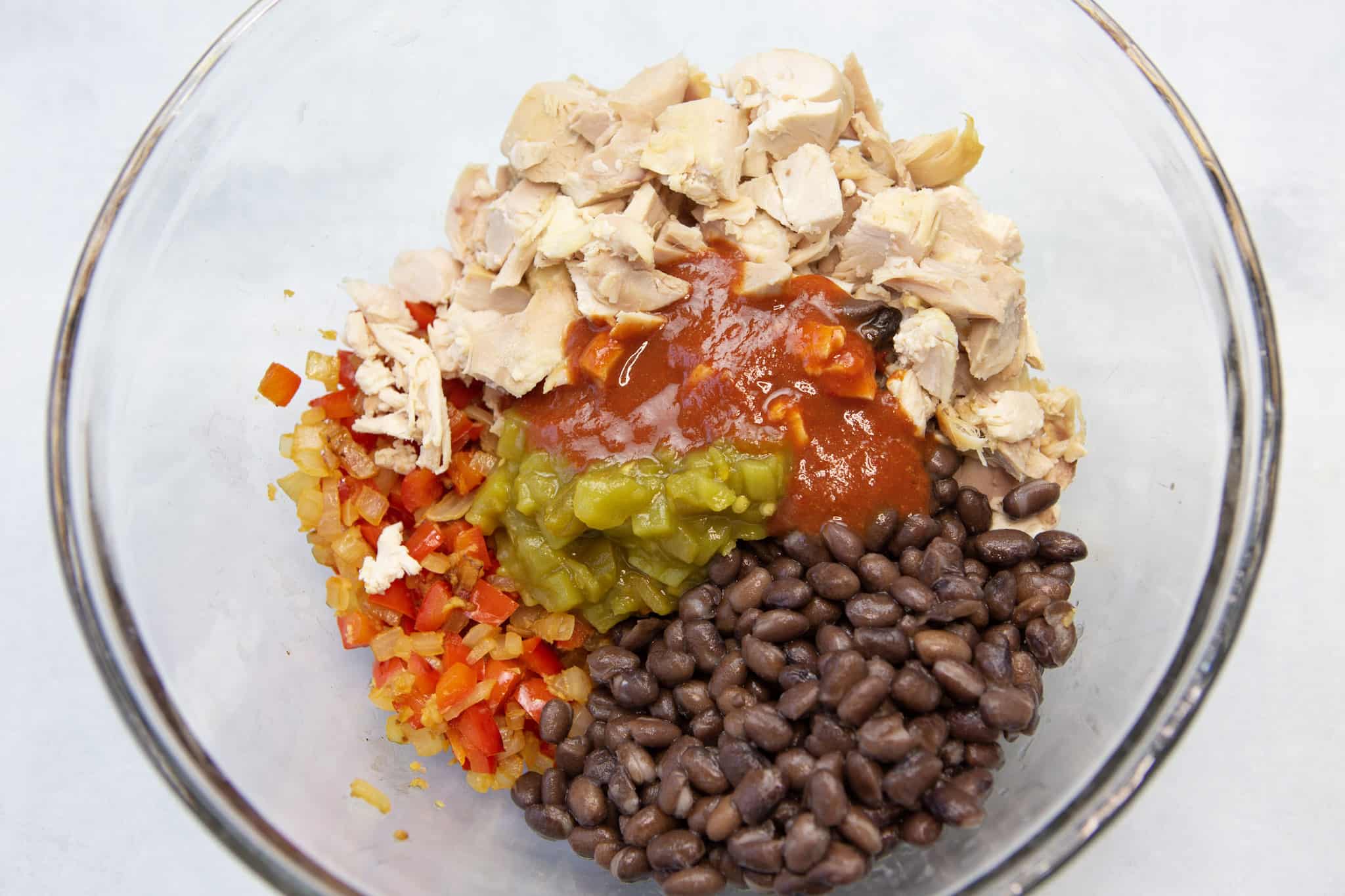 All natural easy chicken enchilada filling ingredients in a mixing bowl.