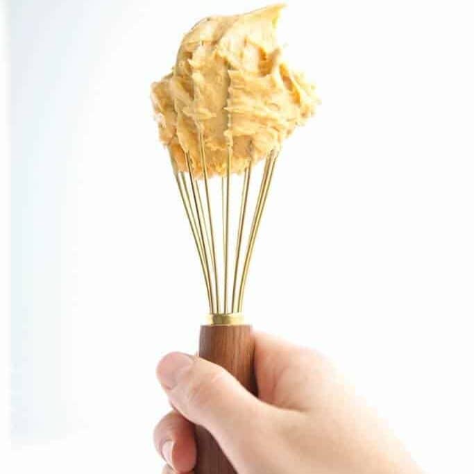 creamy peanut butter frosting dip on a whisk
