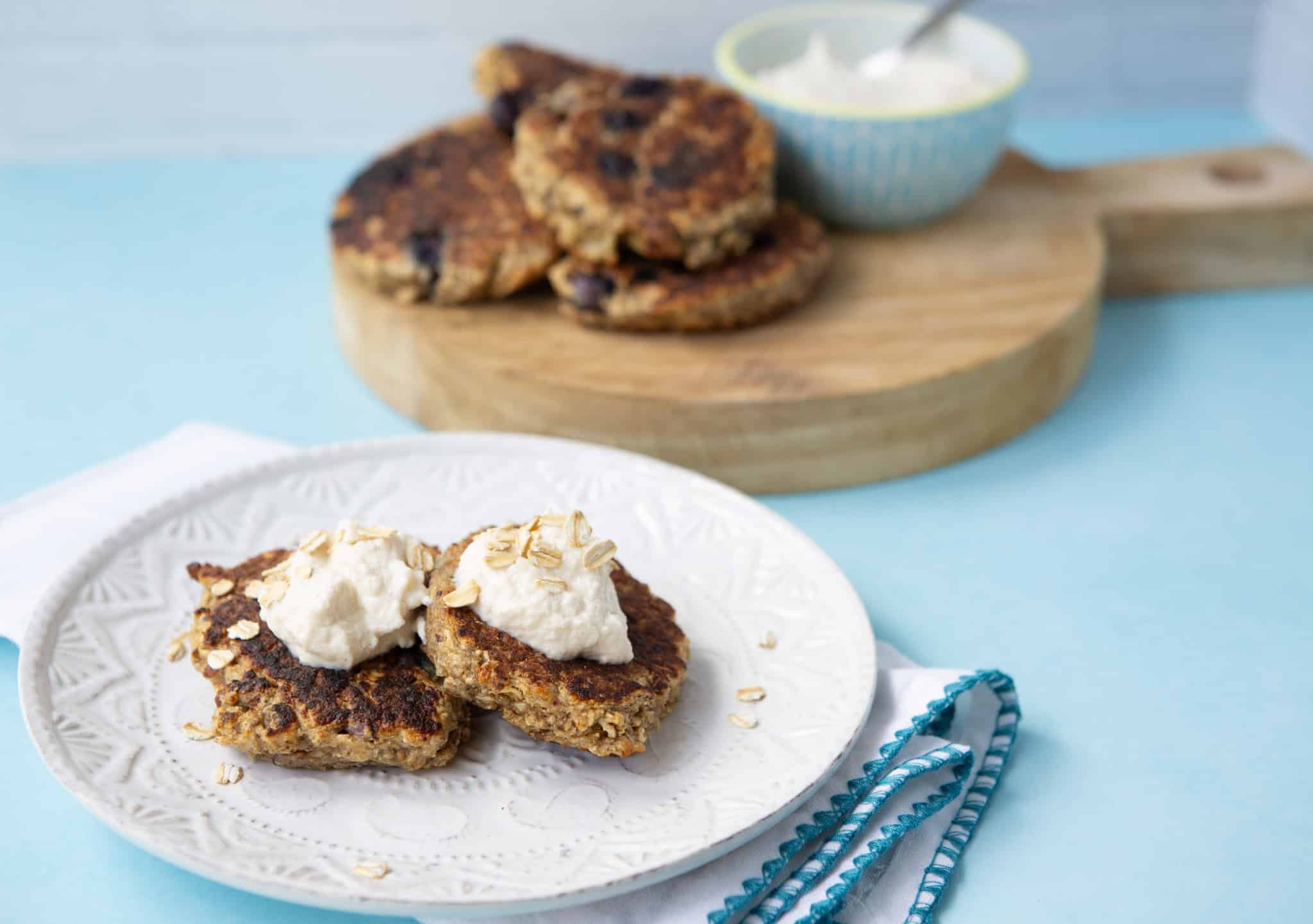 oatmeal griddle cakes on a plate with whipped ricotta topping
