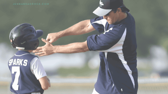 youth baseball coach talking with player about swing