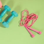 jump rope HIIT workout, jump rope on exercise mat next to two dumbbells