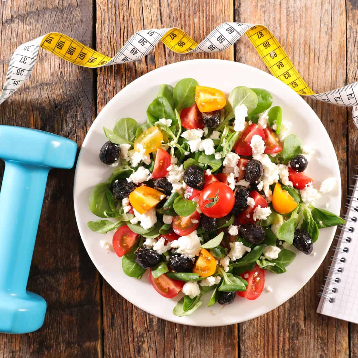 boost glp-1 with natural ways. dumbbell, salad, fabric tape measure, journal