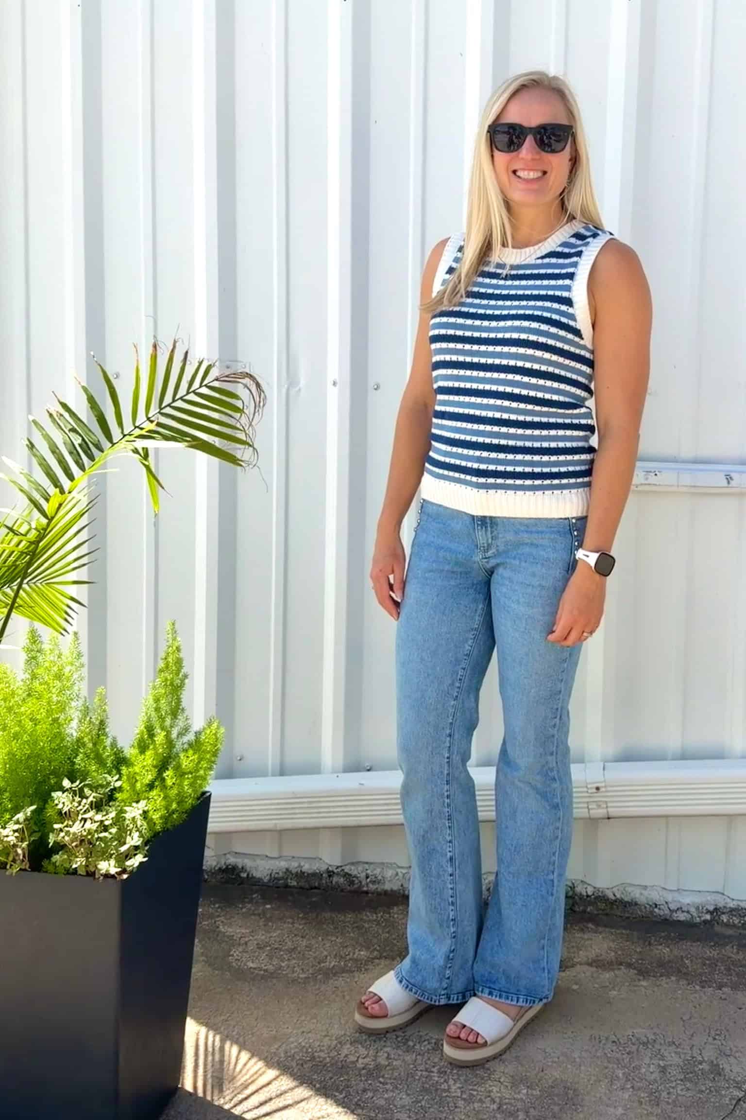 Jenna wearing sunglasses, a striped sleeveless sweater top, and jeans from Stitch Fix